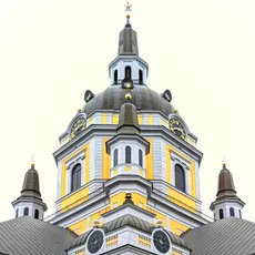 Symmetrical view of Katarina Church’s facade with a prominent dome. The structure features yellow accents, white walls, and dark roofs, set against a bright sky.